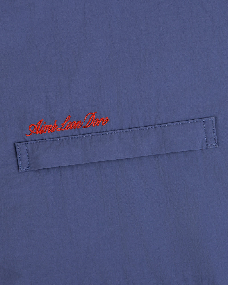 Blue Fleece Lined Sport Windbreaker with a stitched flap and Aimé Leon Dore embroidered in red cursive above.