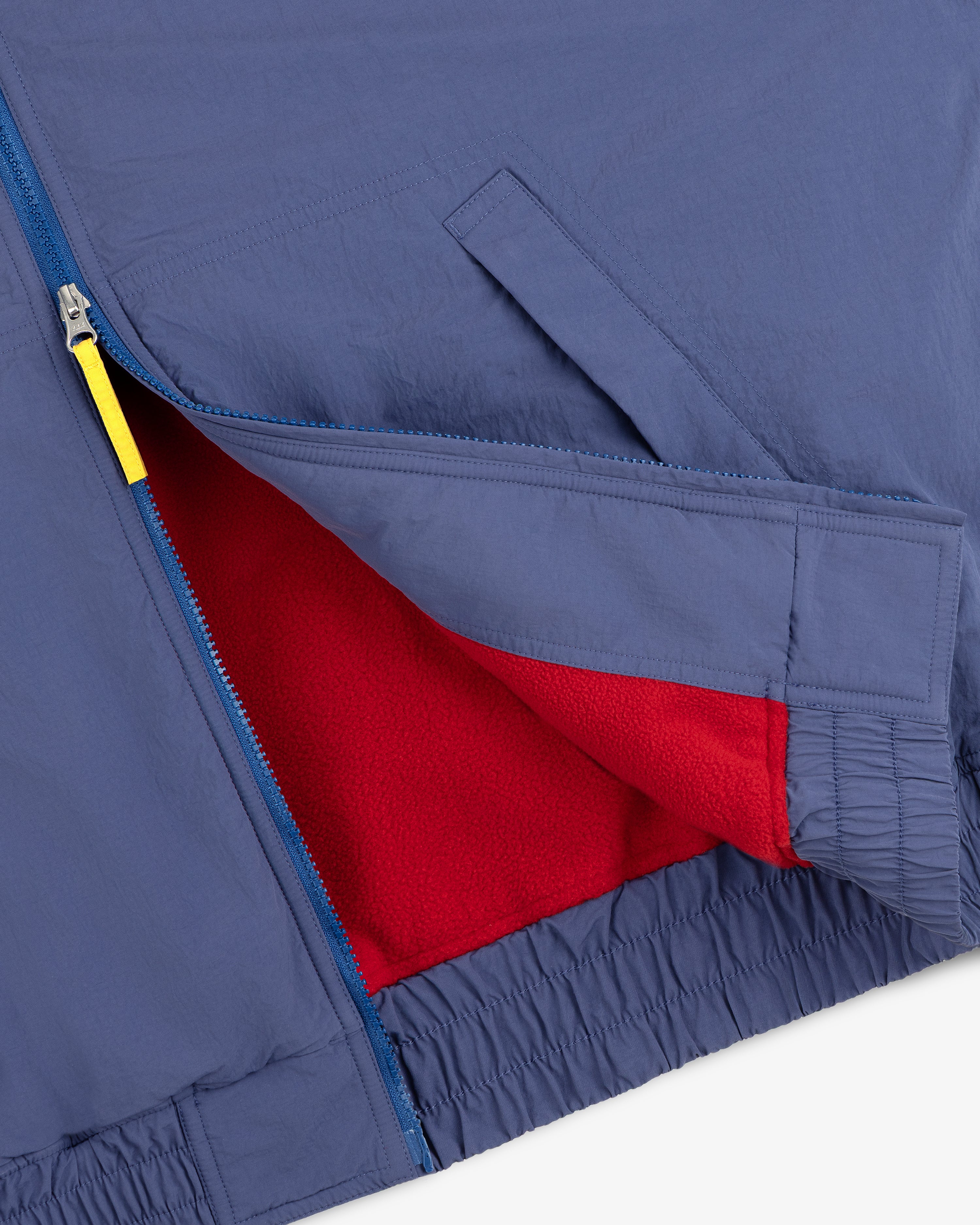Fleece Lined Sport Windbreaker with blue zipper, yellow pull, and red fleece lining visible at the opening.