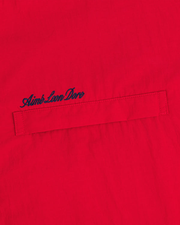 Red Fleece Lined Sport Windbreaker with a horizontal stitched pocket and navy Aimé Leon Dore embroidery above it.