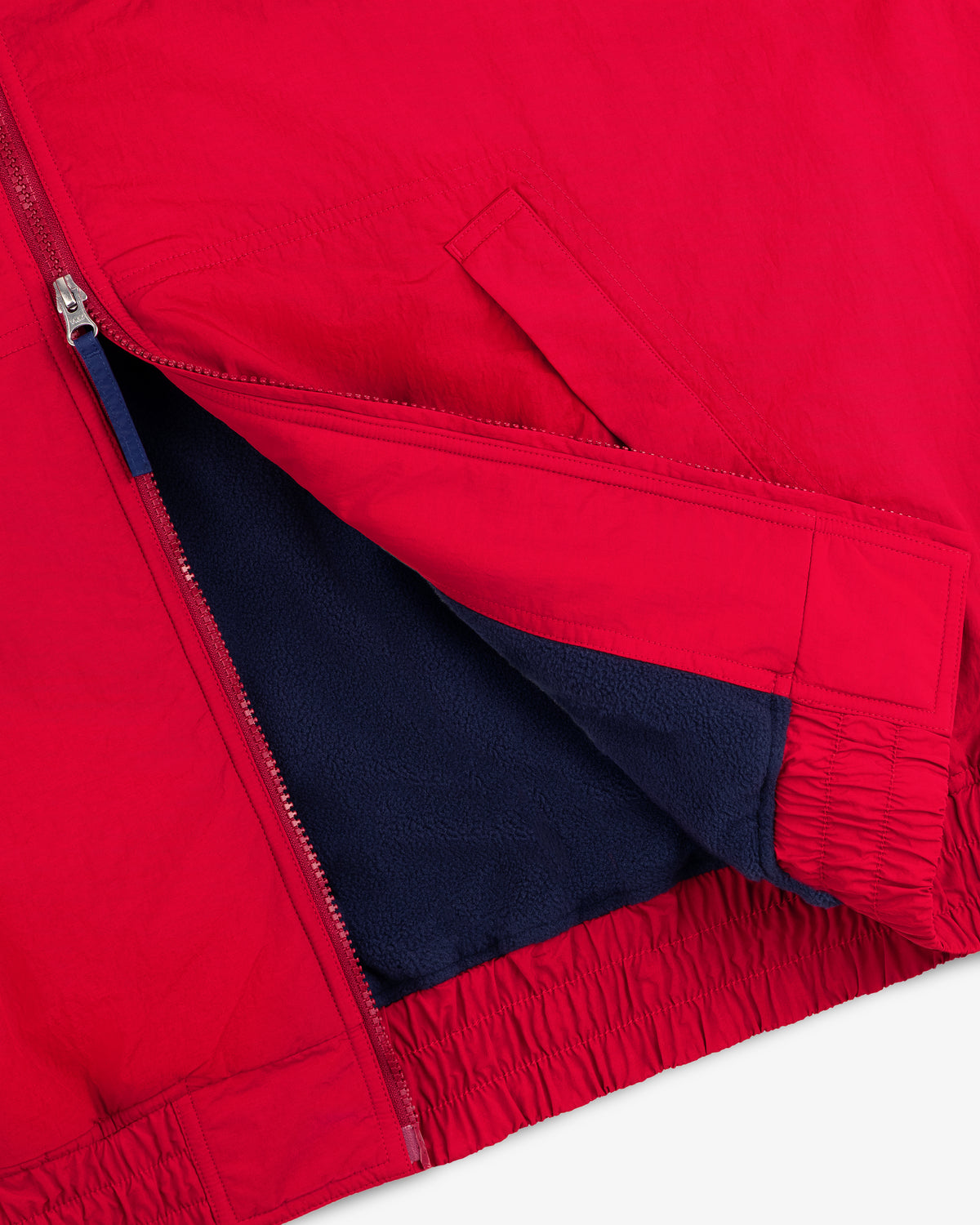 Fleece Lined Sport Windbreaker in red with a zipper, dark blue lining, and an elastic hem.