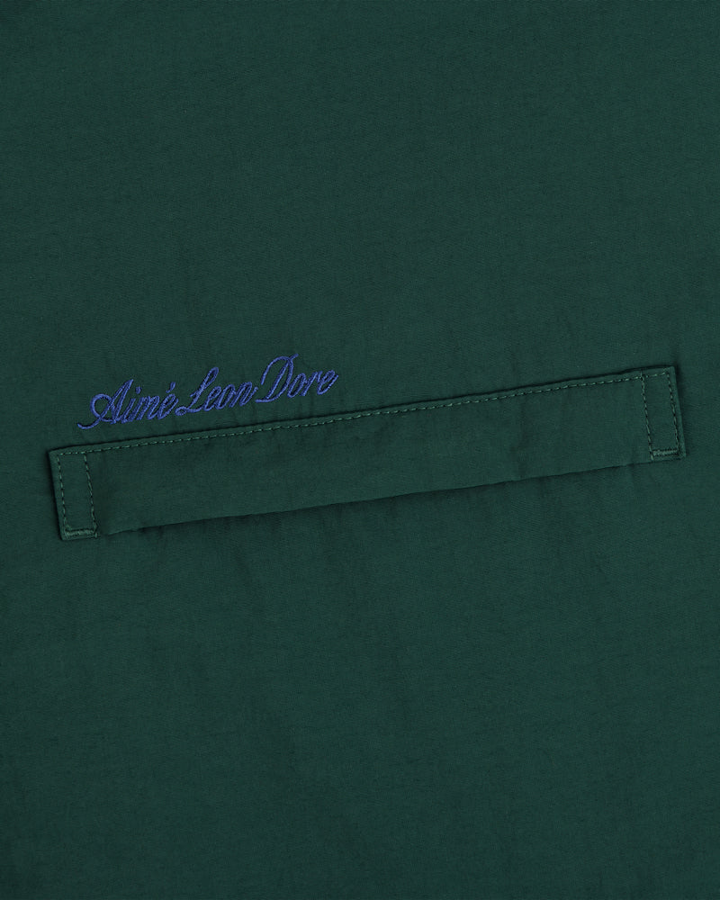 Green fleece lined sport windbreaker with horizontal stitched strip and blue Aimé Leon Dore script embroidered above.