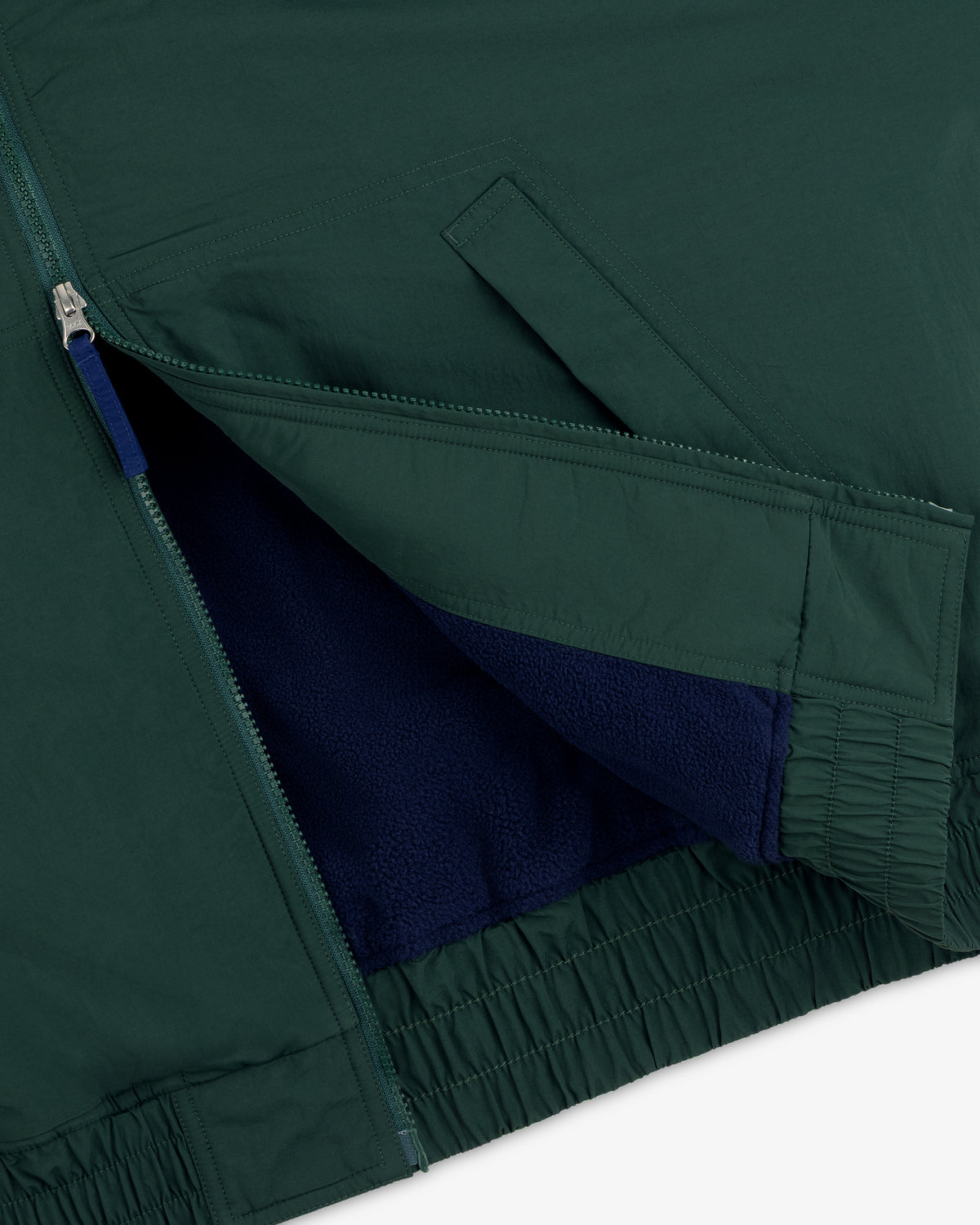 Close-up of the Fleece Lined Sport Windbreaker showing its zip pocket and visible blue fleece lining.