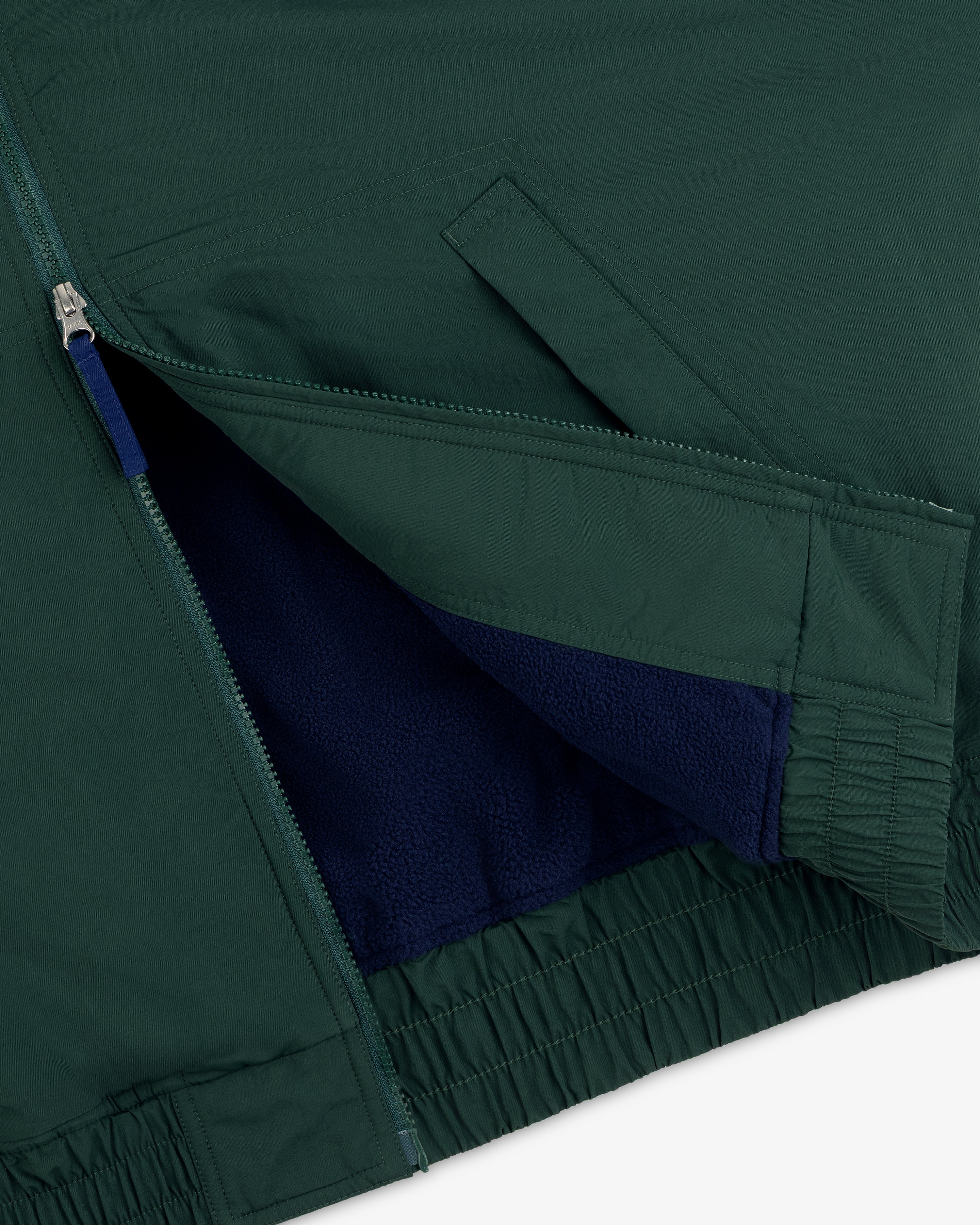 Close-up of the Fleece Lined Sport Windbreaker showing its zip pocket and visible blue fleece lining.