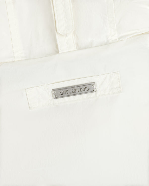 Off-white Down-Filled Surplus Parka featuring a rectangular metal plaque engraved with the text Aime Leon Dore.