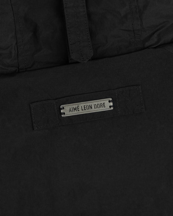 Black Down-Filled Surplus Parka with a hood and a metal Aimé Leon Dore branded plate.