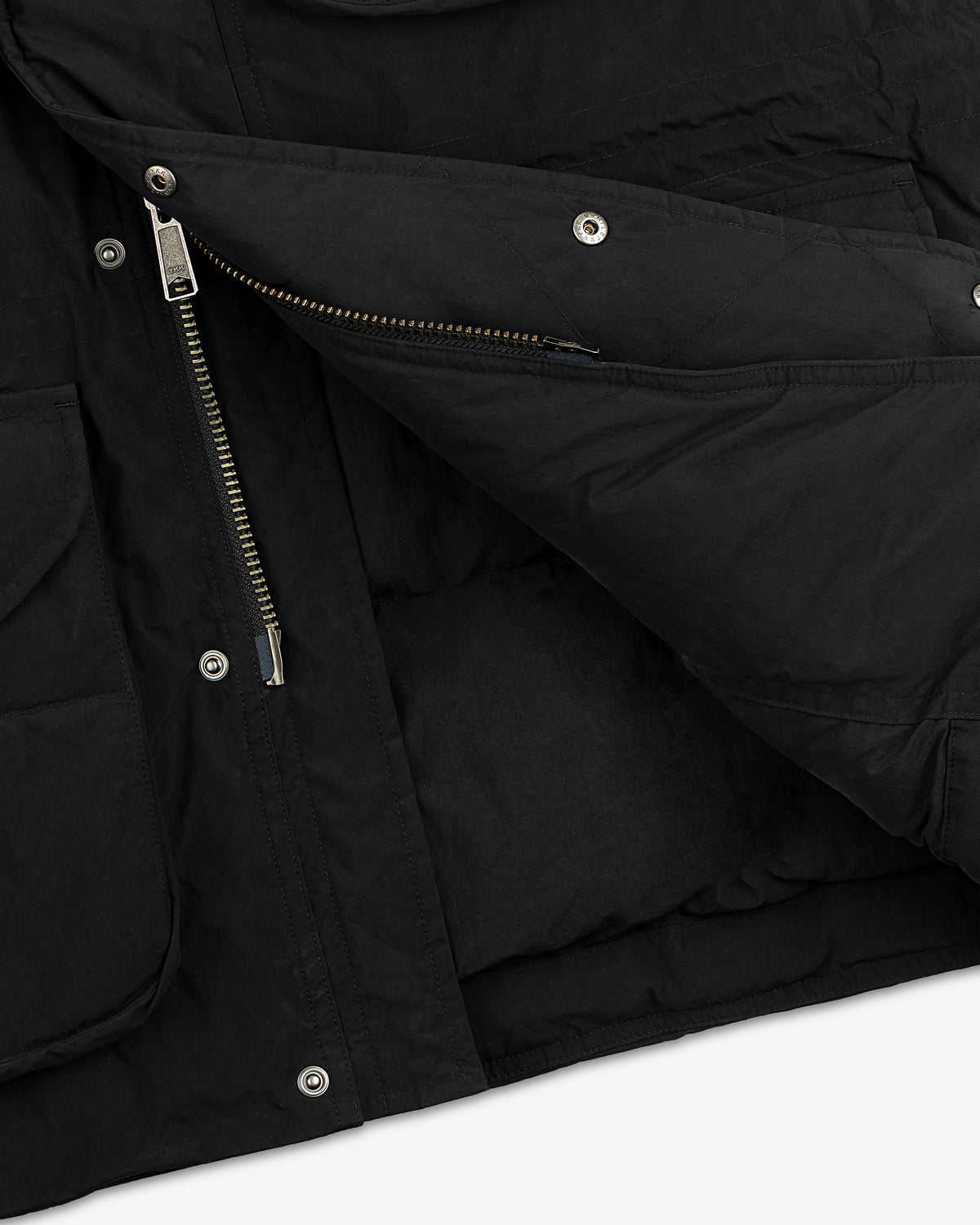 Close-up of a black Down-Filled Surplus Parka with a metal zipper and snap button closure.