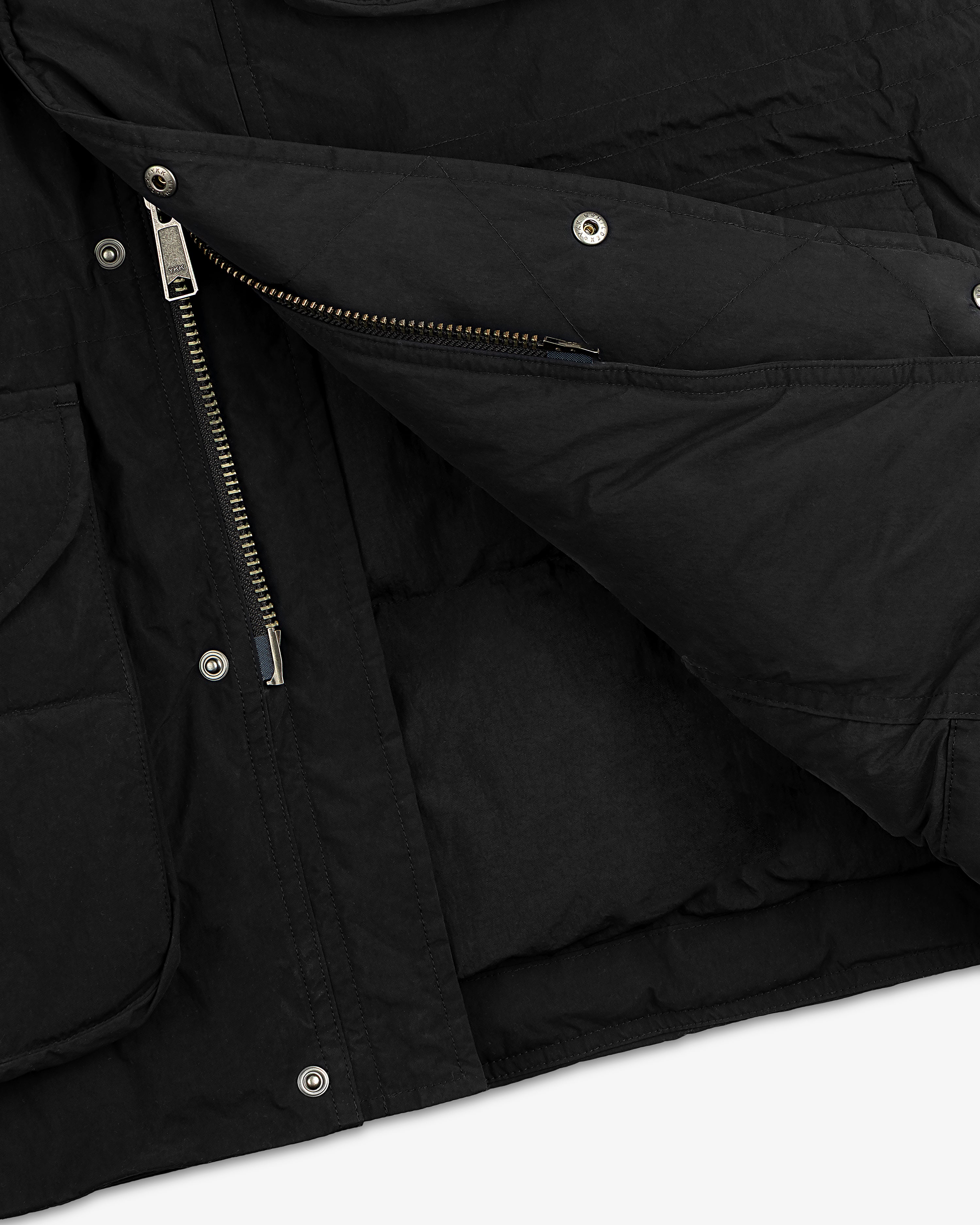 Close-up of a black Down-Filled Surplus Parka with a metal zipper and snap button closure.