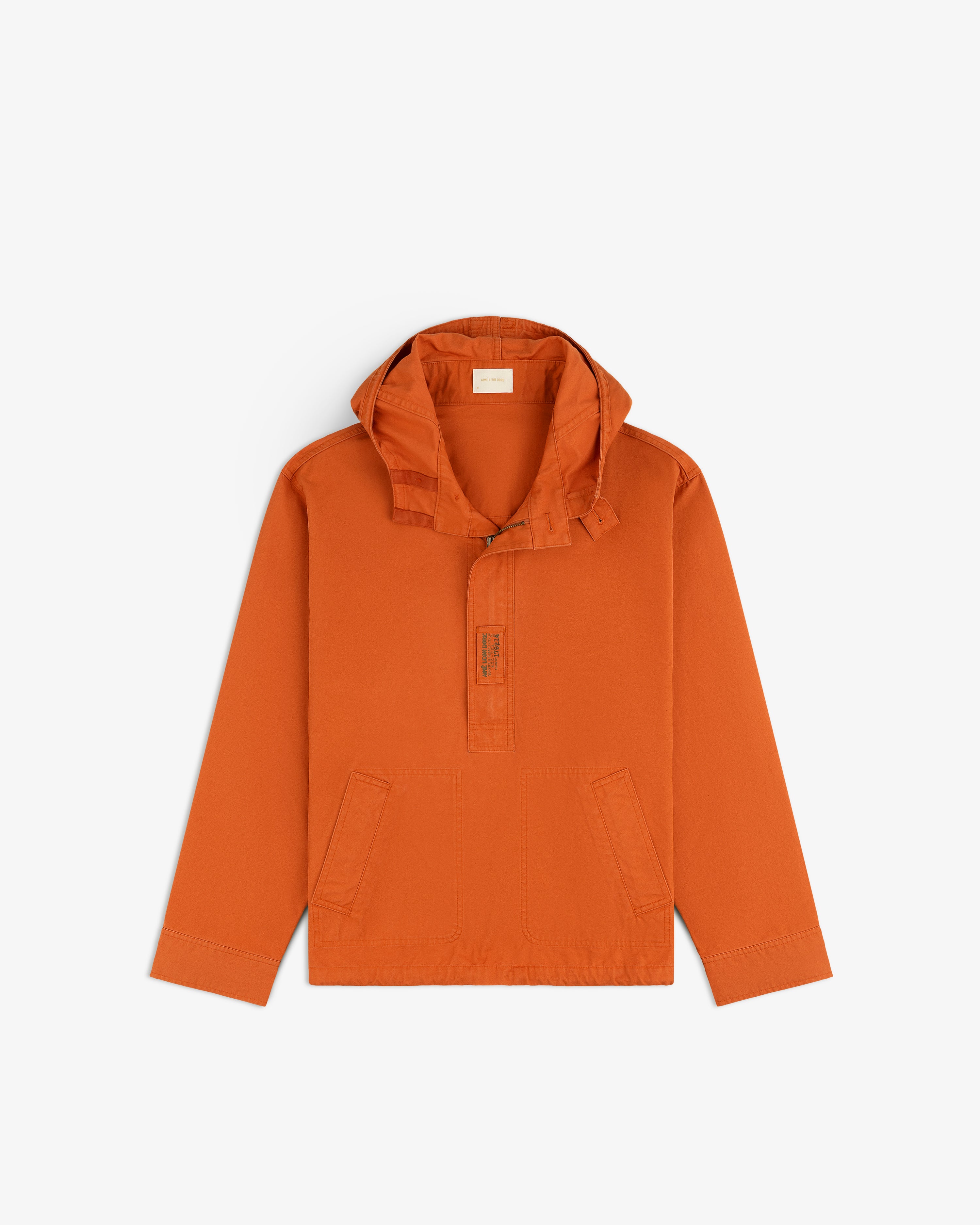 Garment Washed Anorak in burnt orange, featuring a hood, partial front zipper, and two front pockets.