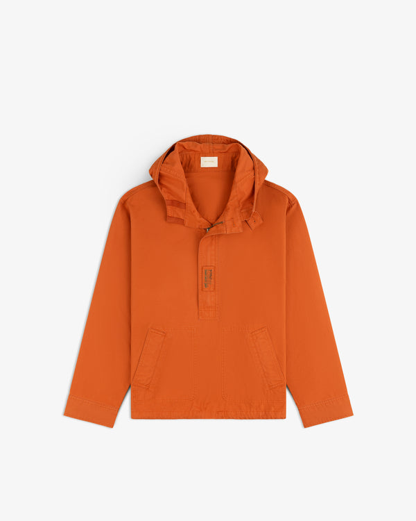 Garment Washed Anorak in burnt orange, featuring a hood, partial front zipper, and two front pockets.