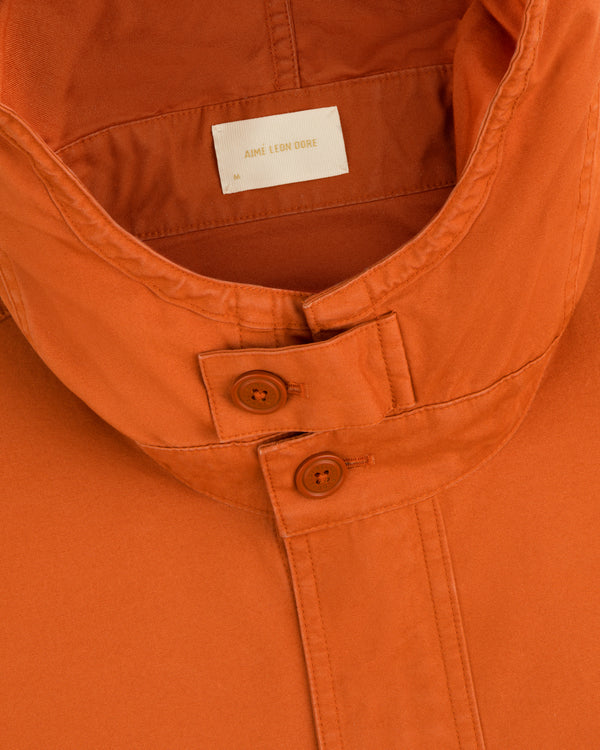 Close-up of a Garment Washed Anorak collar, featuring an orange button-front placket and an interior brand label.