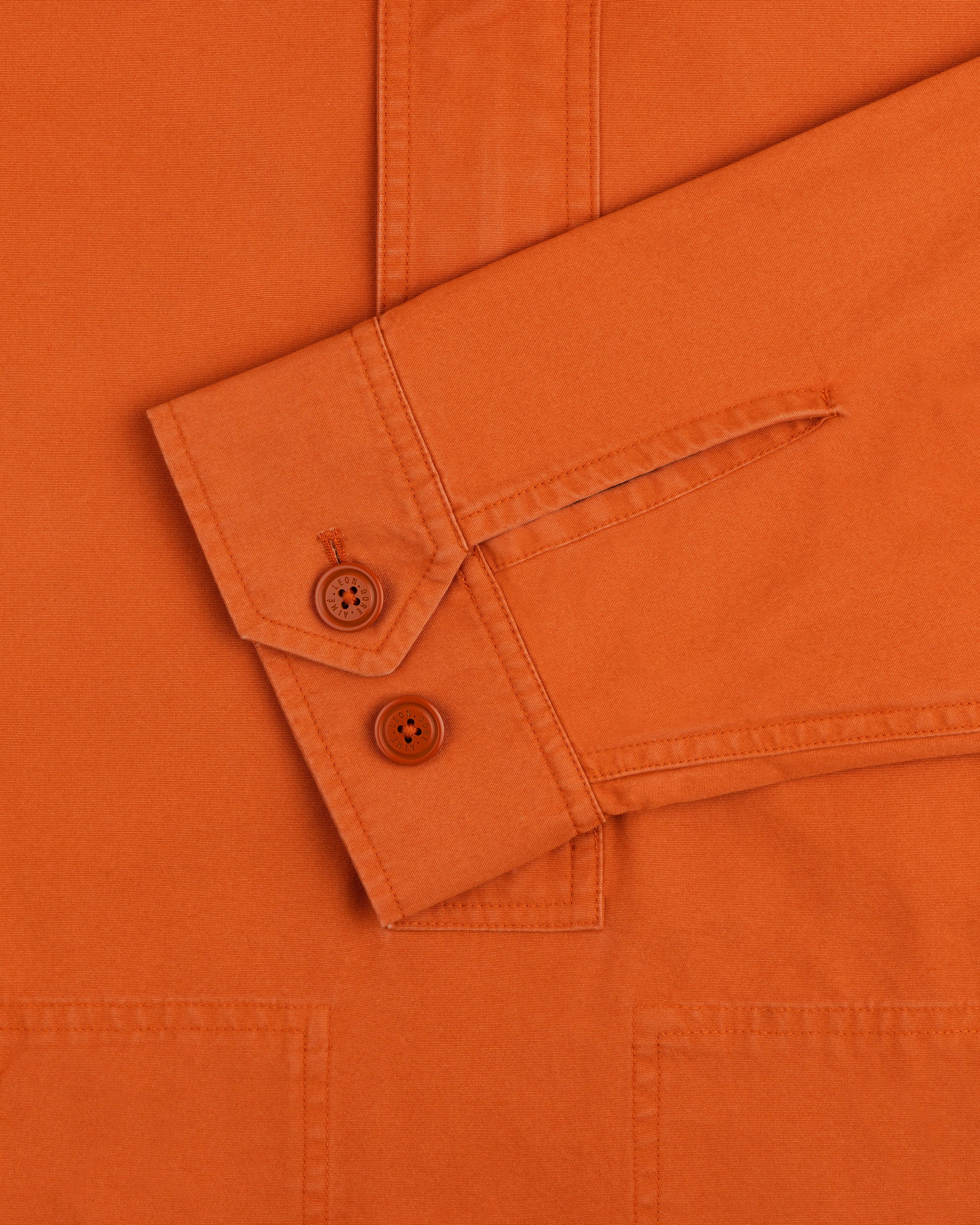 Close-up of the Garment Washed Anorak orange long-sleeve shirt cuff with two matching buttons.