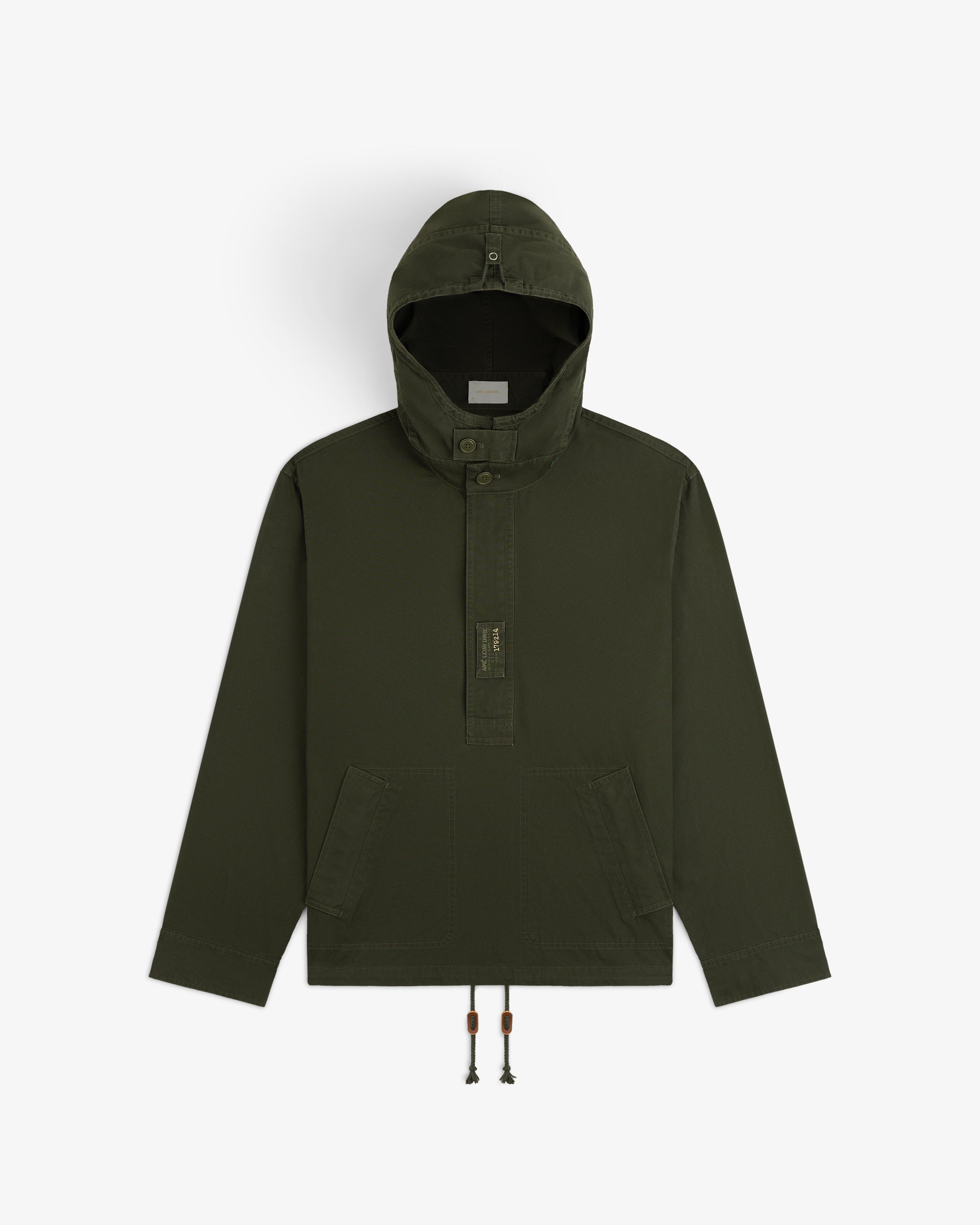 Garment Washed Anorak in olive green with a hooded pullover design, button placket, front pockets, and drawstring hem.