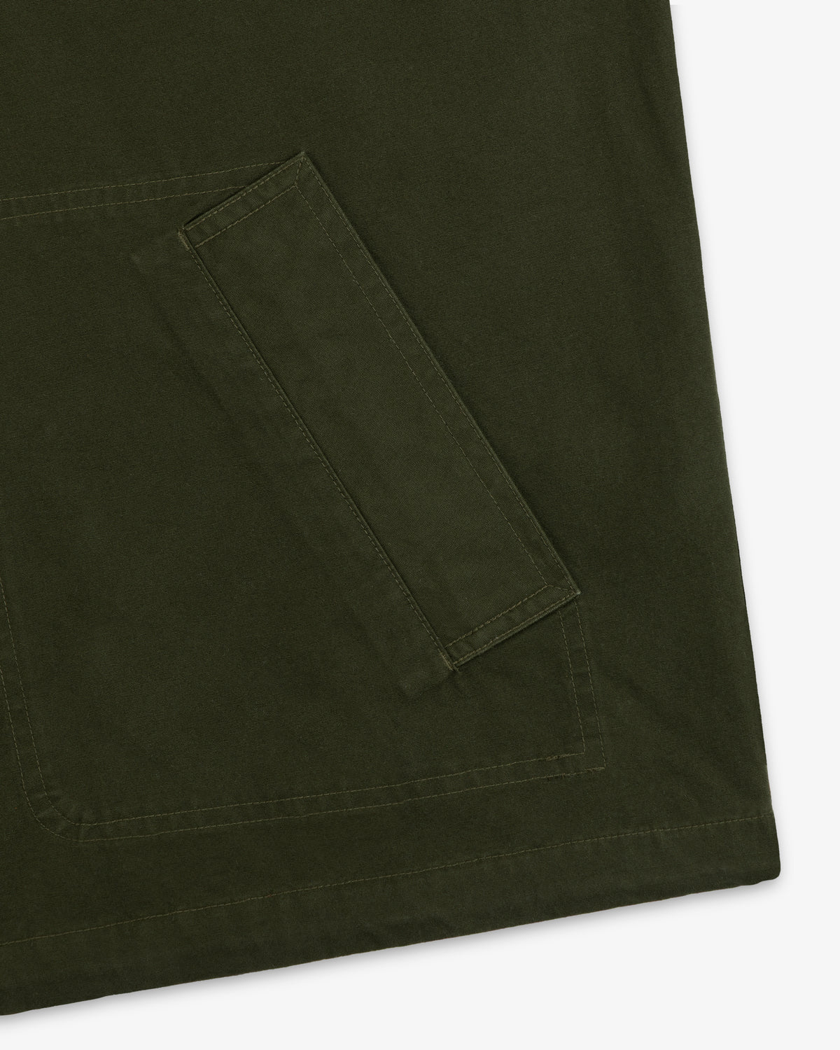 Close-up of a large olive green pocket with stitched detailing on a Garment Washed Anorak.