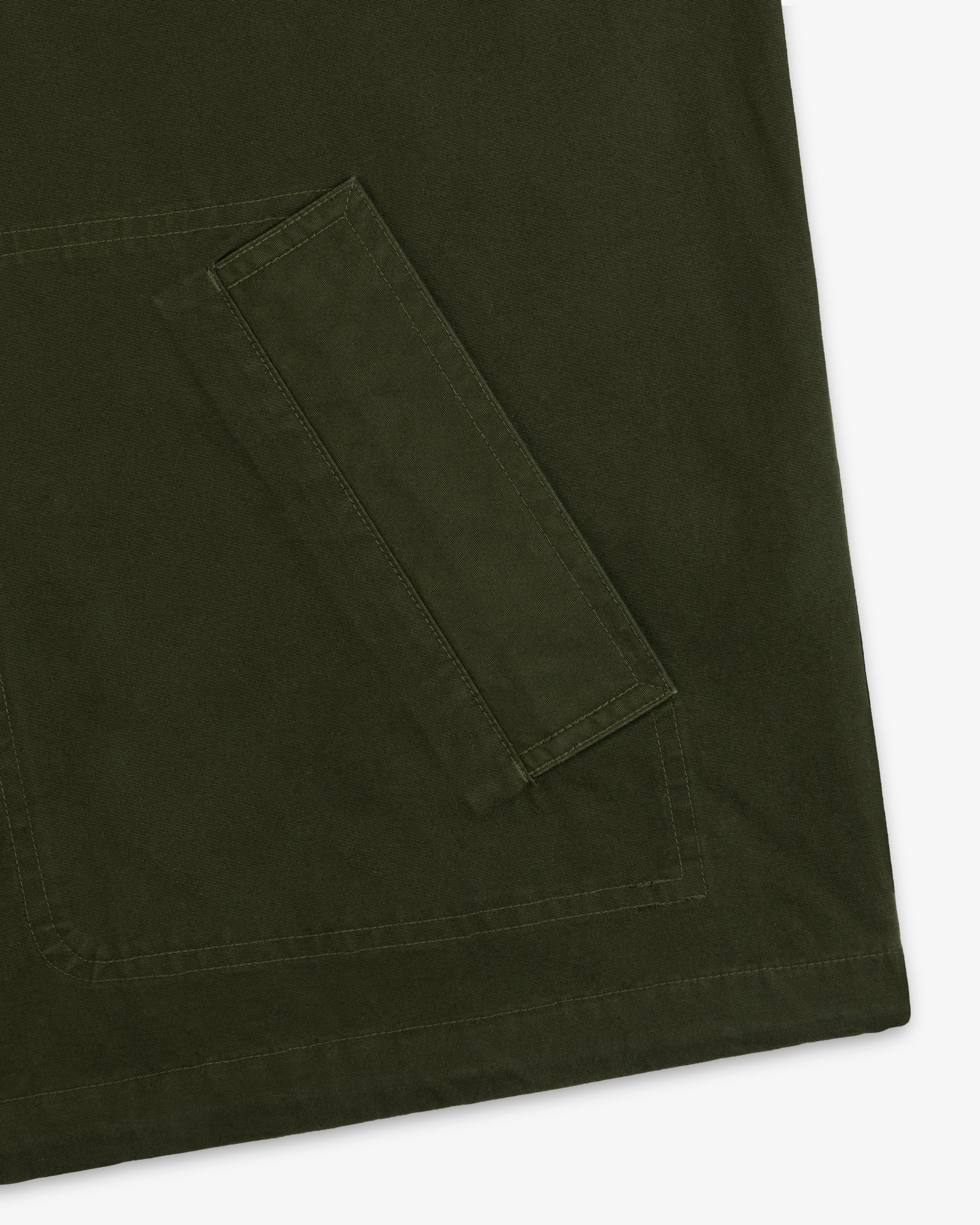 Close-up of a large olive green pocket with stitched detailing on a Garment Washed Anorak.