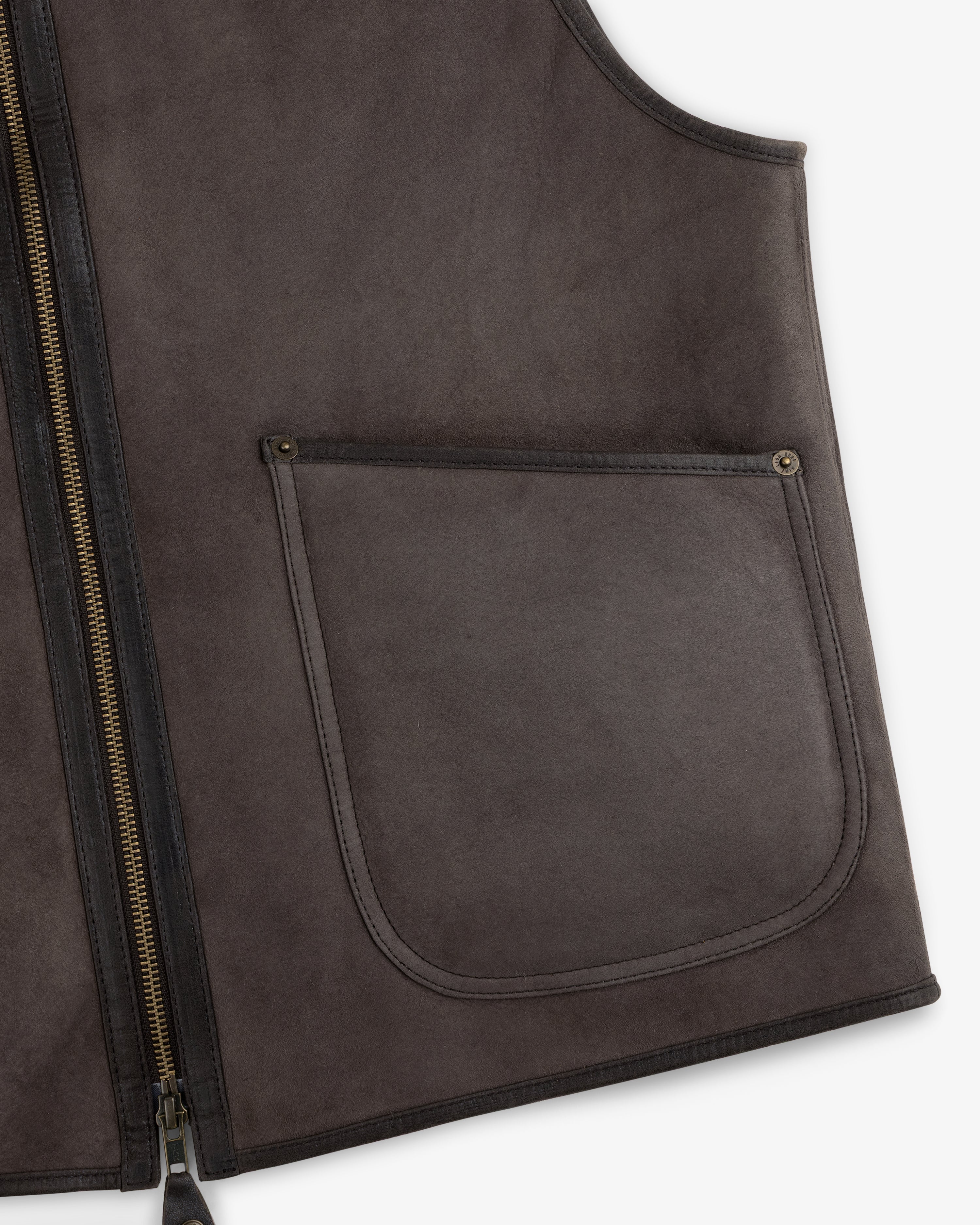 Dark brown suede Shearling Biker Vest with a front zipper closure and a large patch pocket with rivet detailing.