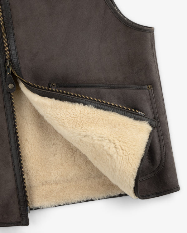 Shearling Biker Vest in dark brown suede with an off-white fleece lining and an open front zipper.