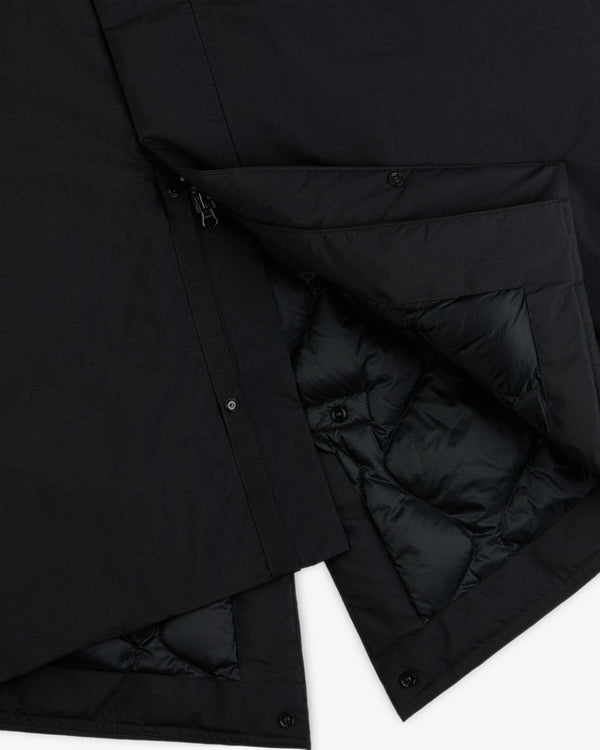 Close-up of a black GORE-TEX Down Filled Fishtail Parka showing the zipper, snap buttons, and quilted interior lining.