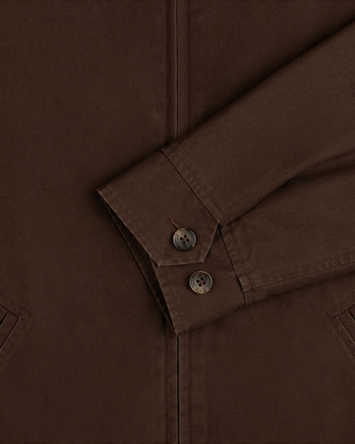 Close-up of a brown Fleece Lined Mechanic Jacket sleeve with two buttons on the cuff.