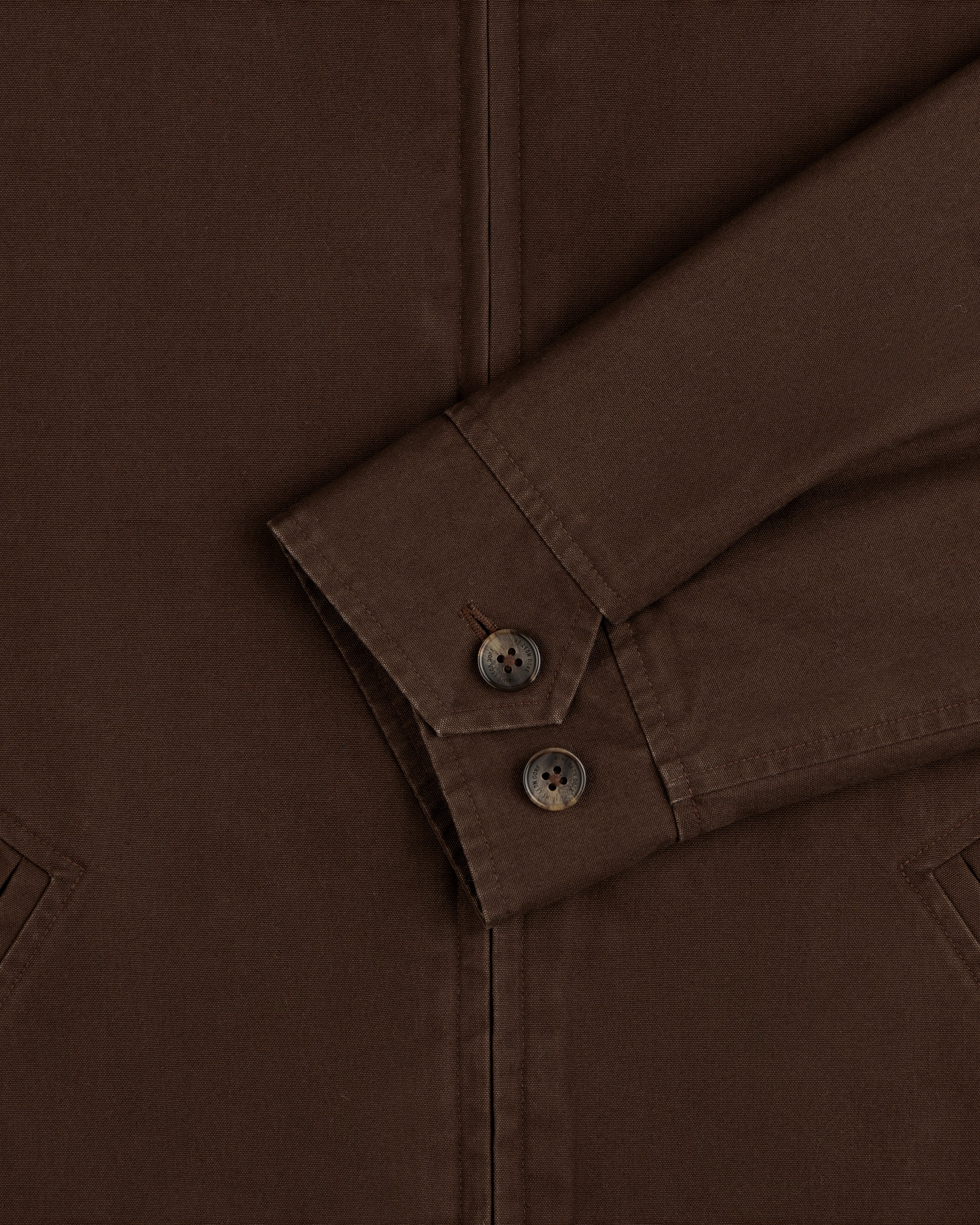 Close-up of a brown Fleece Lined Mechanic Jacket sleeve with two buttons on the cuff.