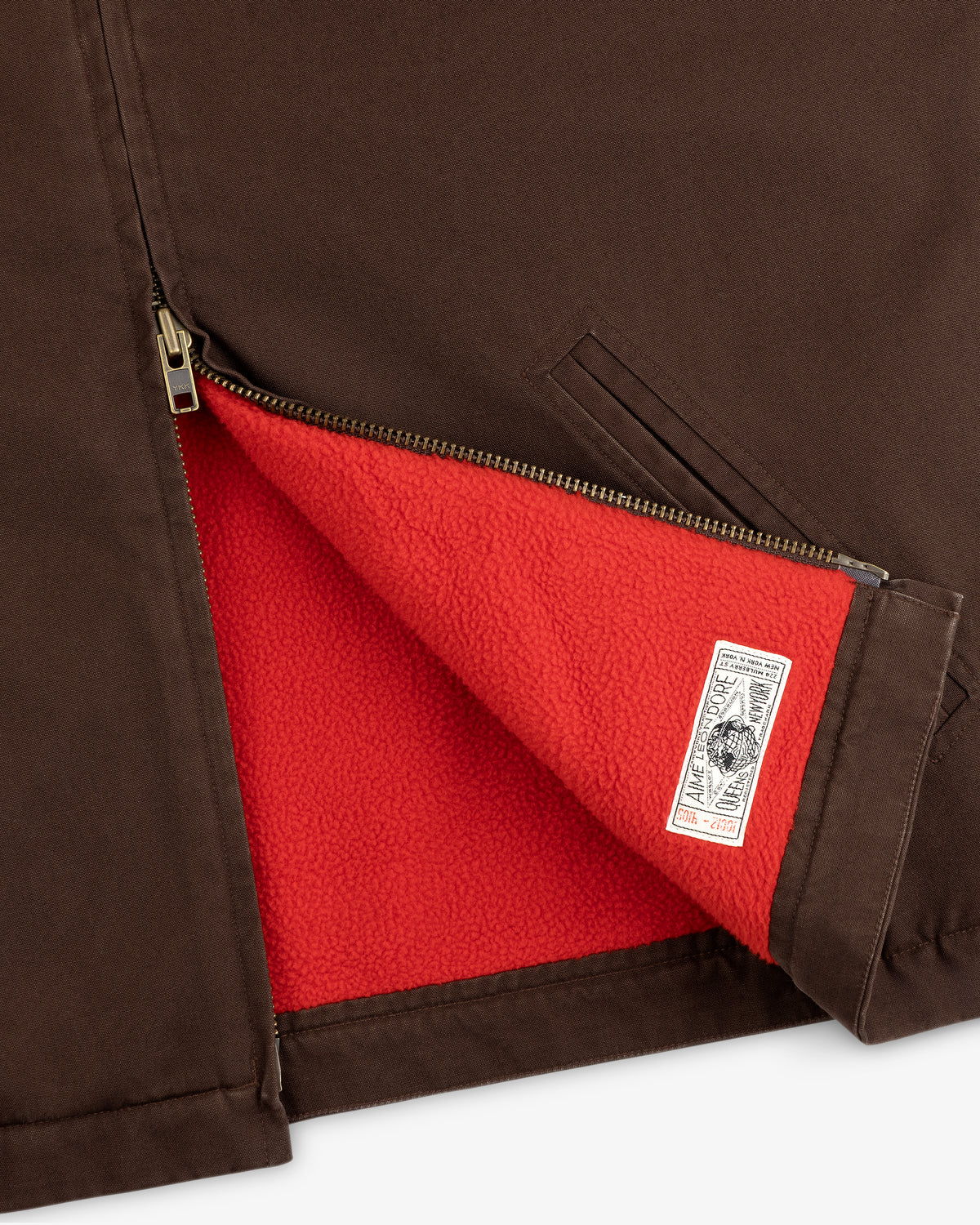 Fleece Lined Mechanic Jacket in brown, partially unzipped to reveal a red fleece lining and brand tag.