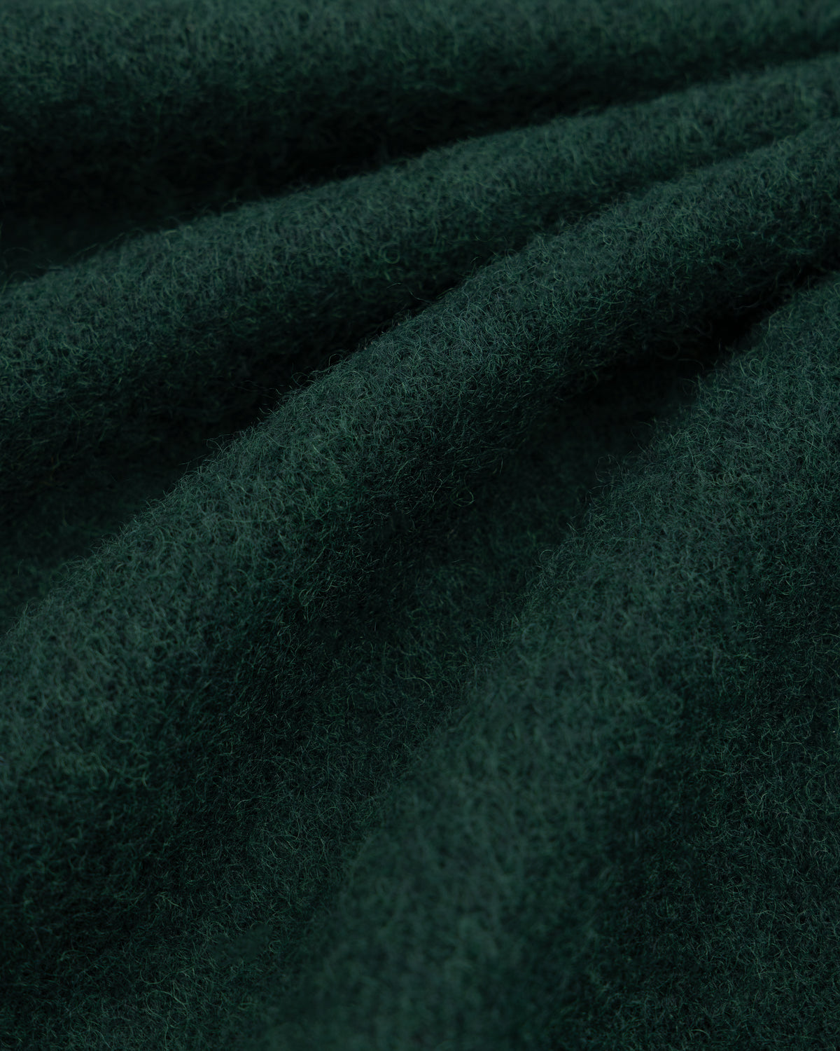 Dark green, textured Wool Sport Coat fabric folded in soft waves.