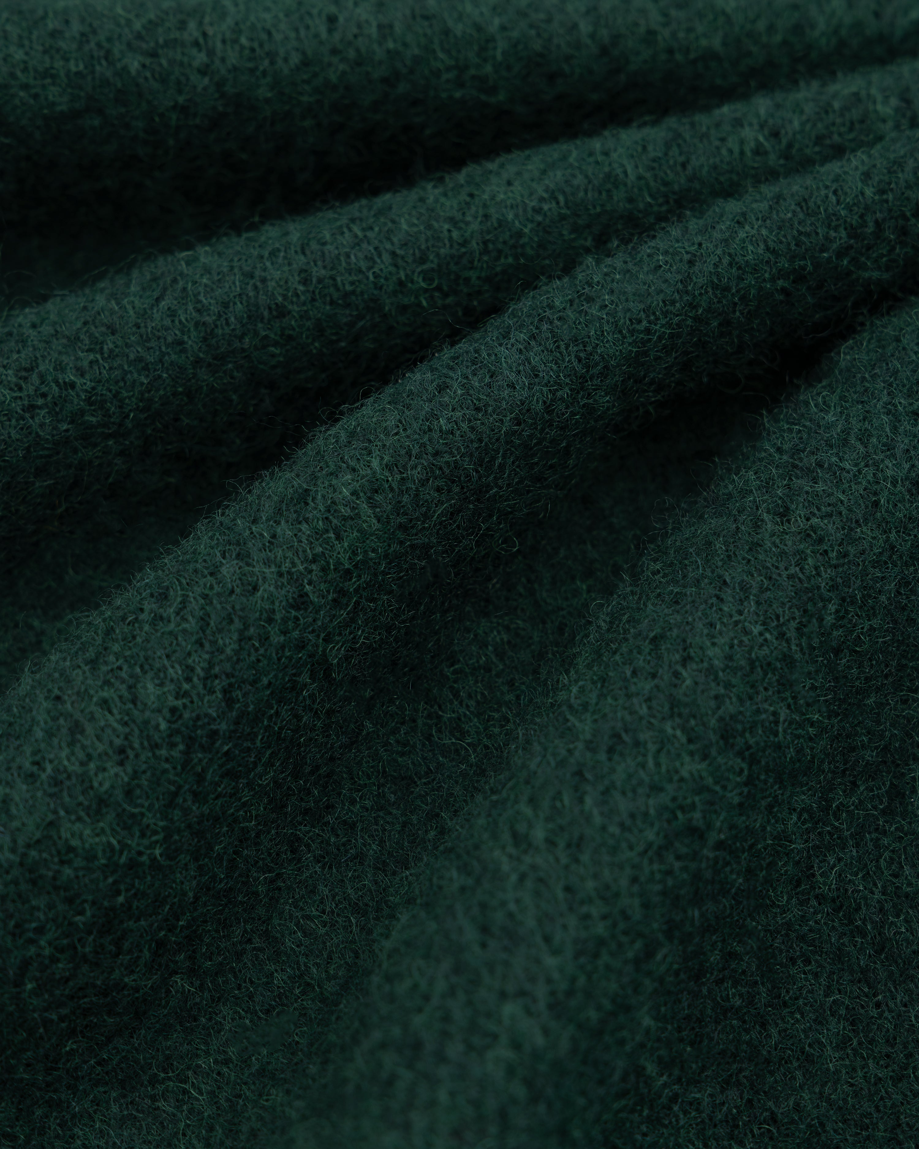 Dark green, textured Wool Sport Coat fabric folded in soft waves.