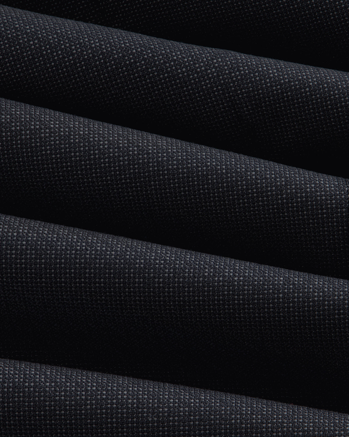 Close-up of a Double-Breasted Wool Jacquard Suit Jacket featuring dark, textured fabric with prominent diagonal folds.
