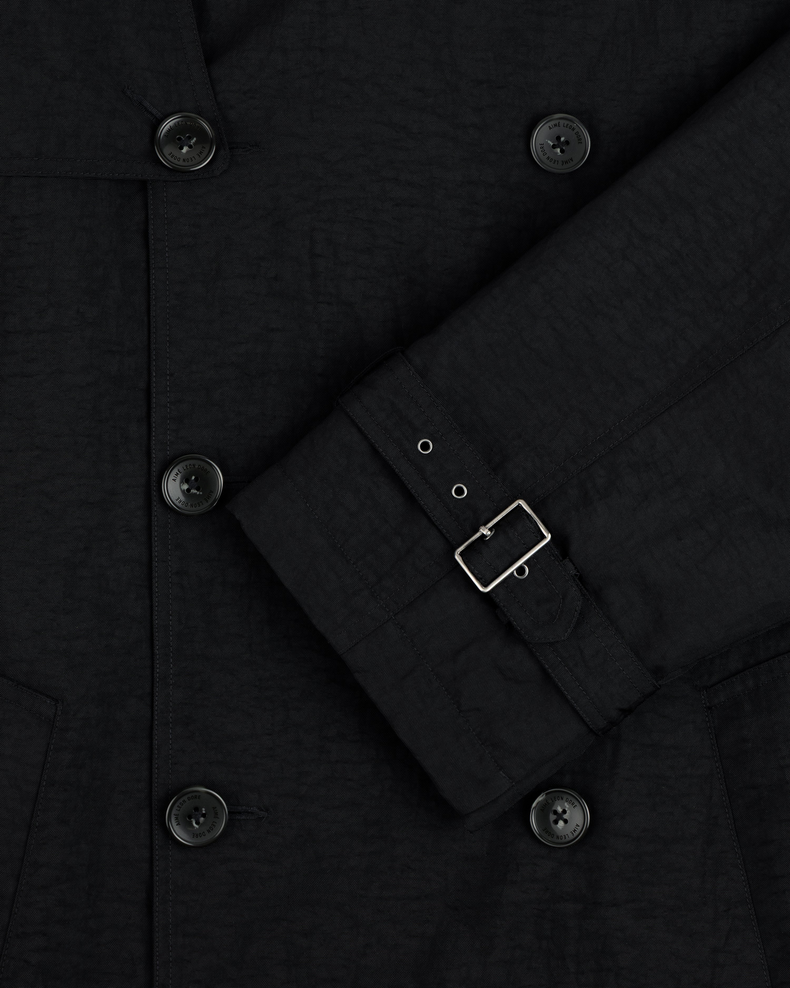 Close-up of Double Breasted Nylon Trench Coat with belted sleeve detail against a plain background.
