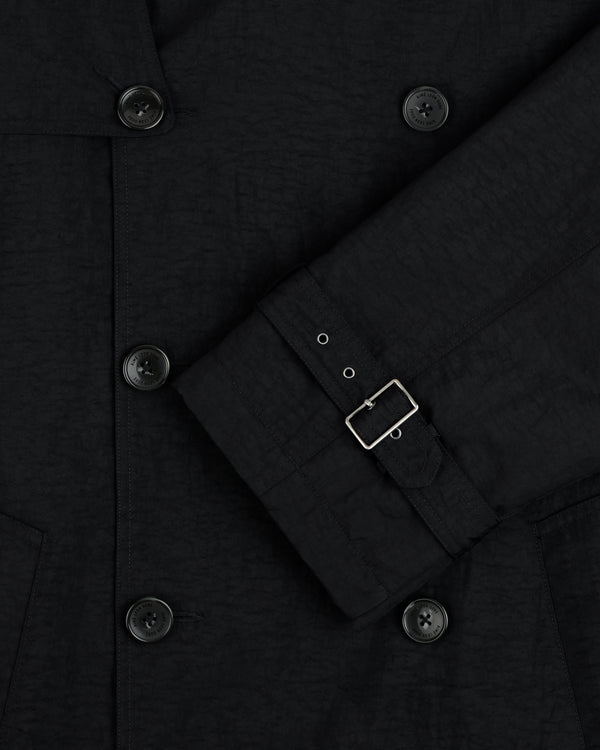 Close-up of Double Breasted Nylon Trench Coat with belted sleeve detail against a plain background.
