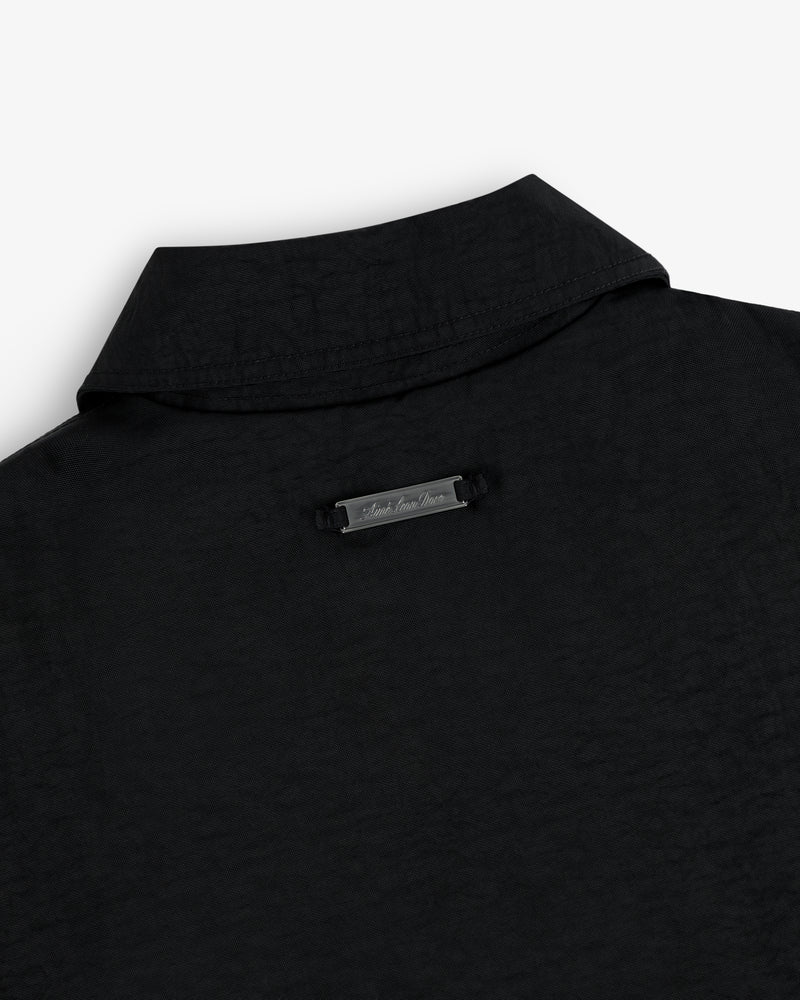 Close-up of the back collar of a nylon trench coat with a small metallic label below the collar.
