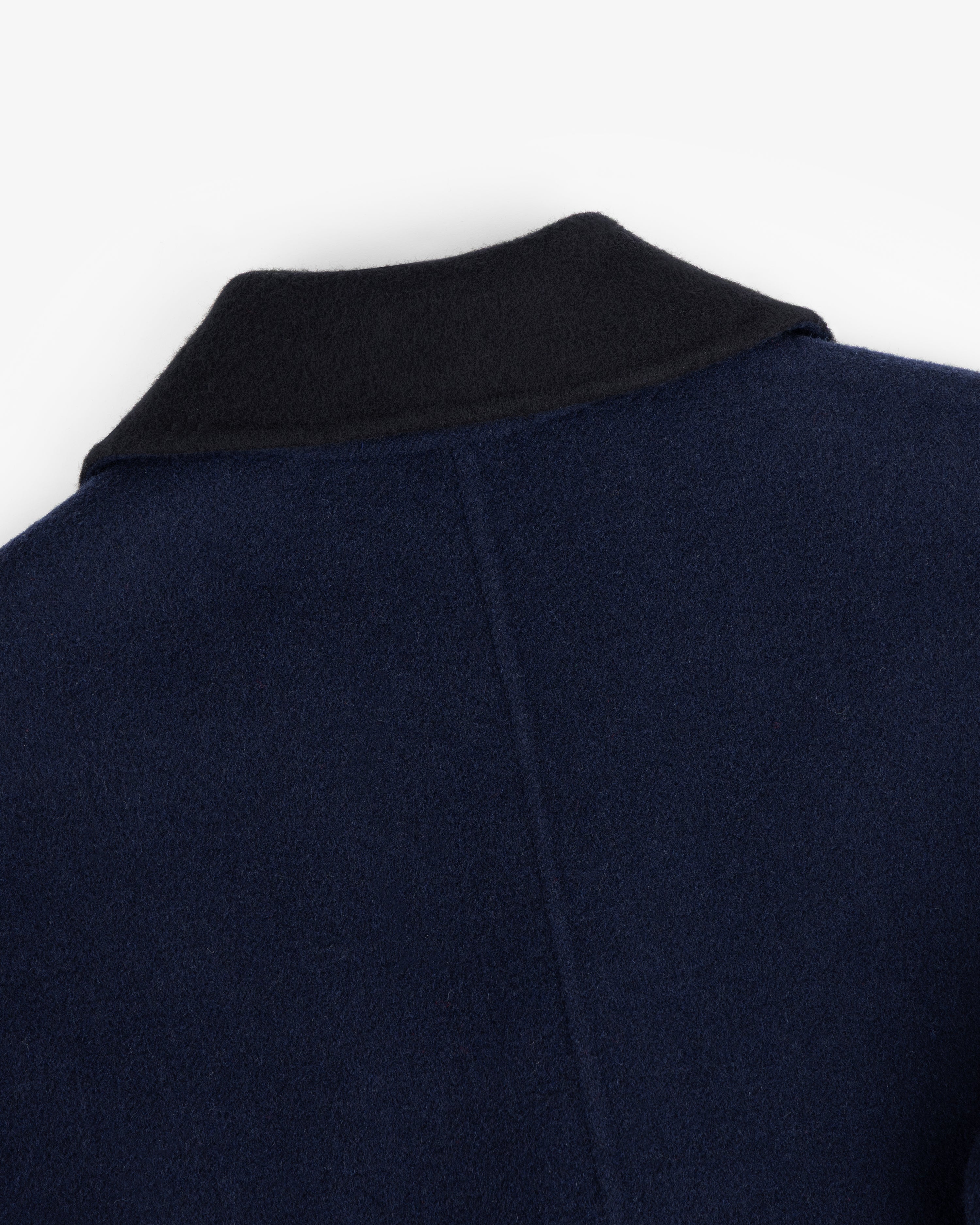 Close-up of a Reversible Double Breasted Top Coat in navy with a black collar.