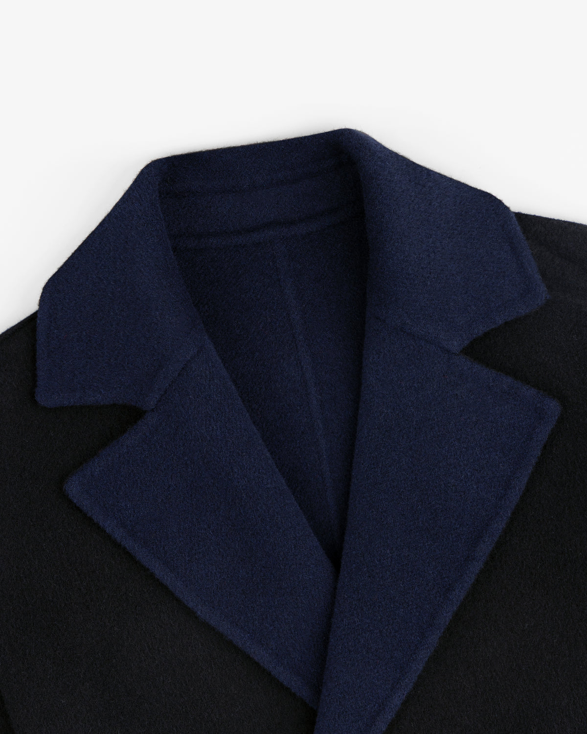 Close-up of a Reversible Double Breasted Top Coat with a dark blue collar and black body.