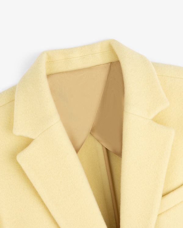 Close-up of a pale yellow Wool Sportcoat with a tan lining at the collar.