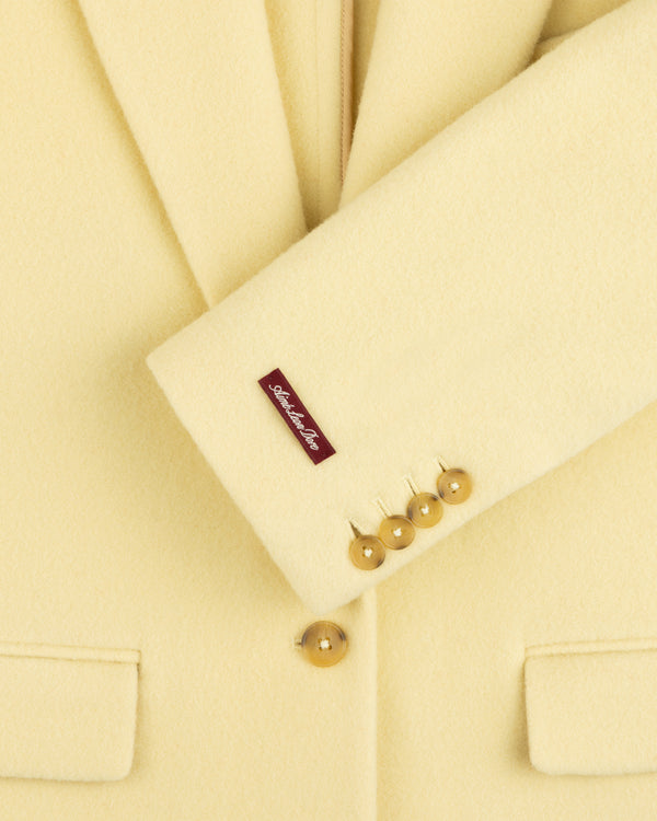 Pale yellow Wool Sportcoat with four buttons on the cuff and a label on the sleeve.