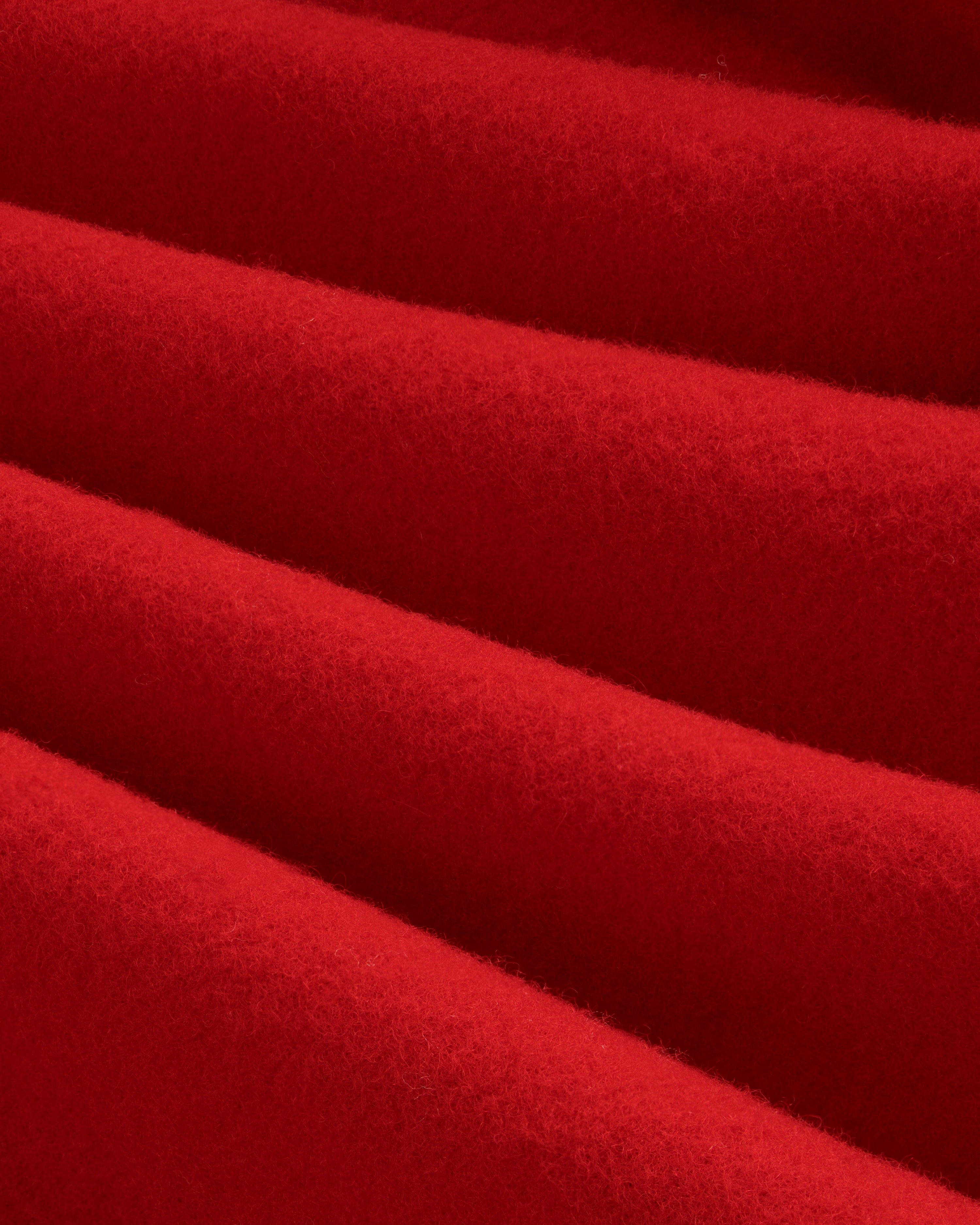 Close-up of red felted Wool Sportcoat fabric with diagonal folds.