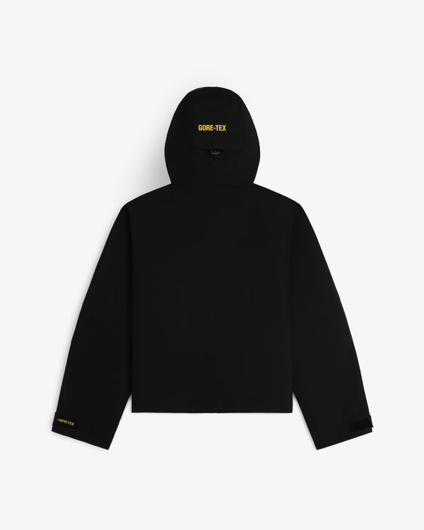 Back view of a black Cropped GORE-TEX Shell Jacket with yellow logos on the hood and sleeve.