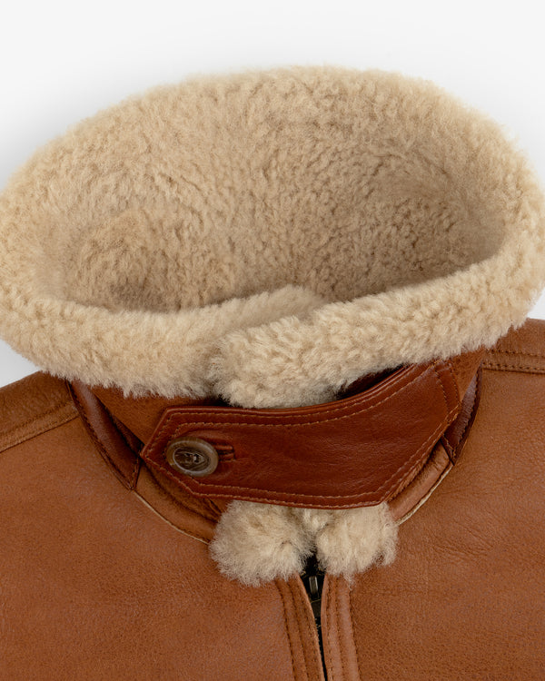 Shearling Bomber Jacket in brown leather with a large beige shearling collar and a buttoned throat latch.