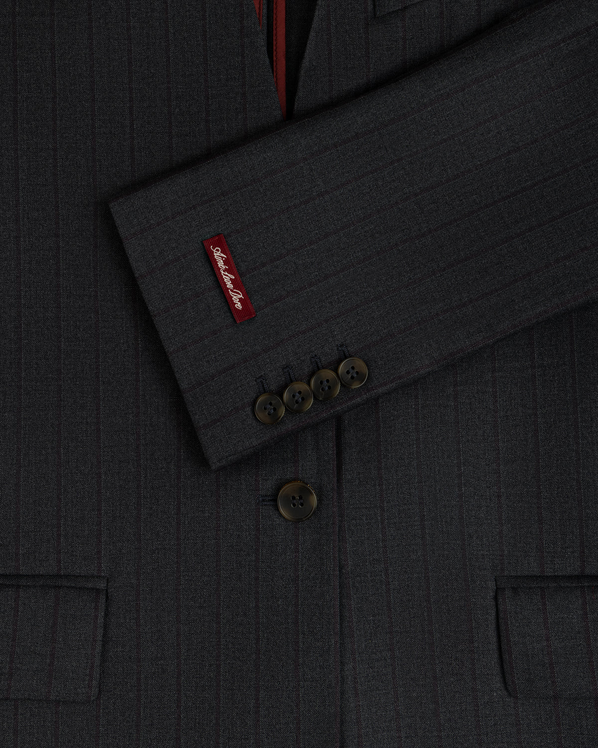 Collarless Striped Blazer in dark charcoal pinstripe with a branded red cuff tab and four-button sleeves.