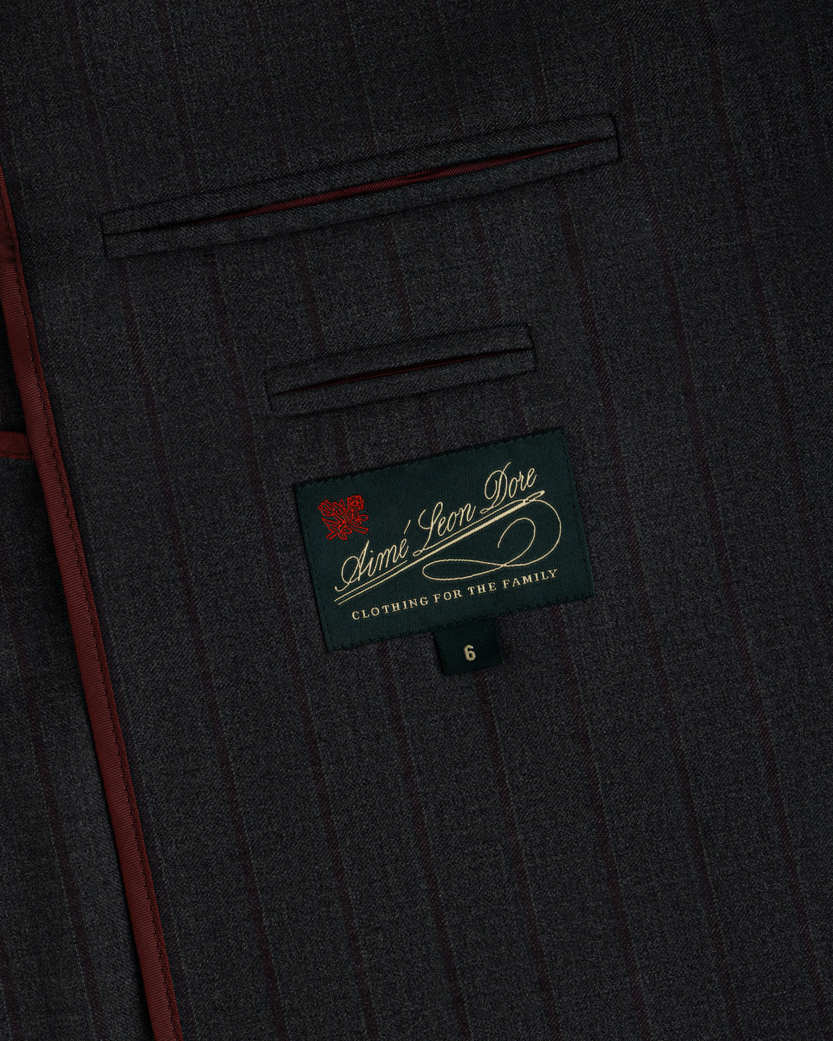 Dark gray pinstriped Collarless Striped Blazer fabric with a branded interior label and the number six on a small tab.