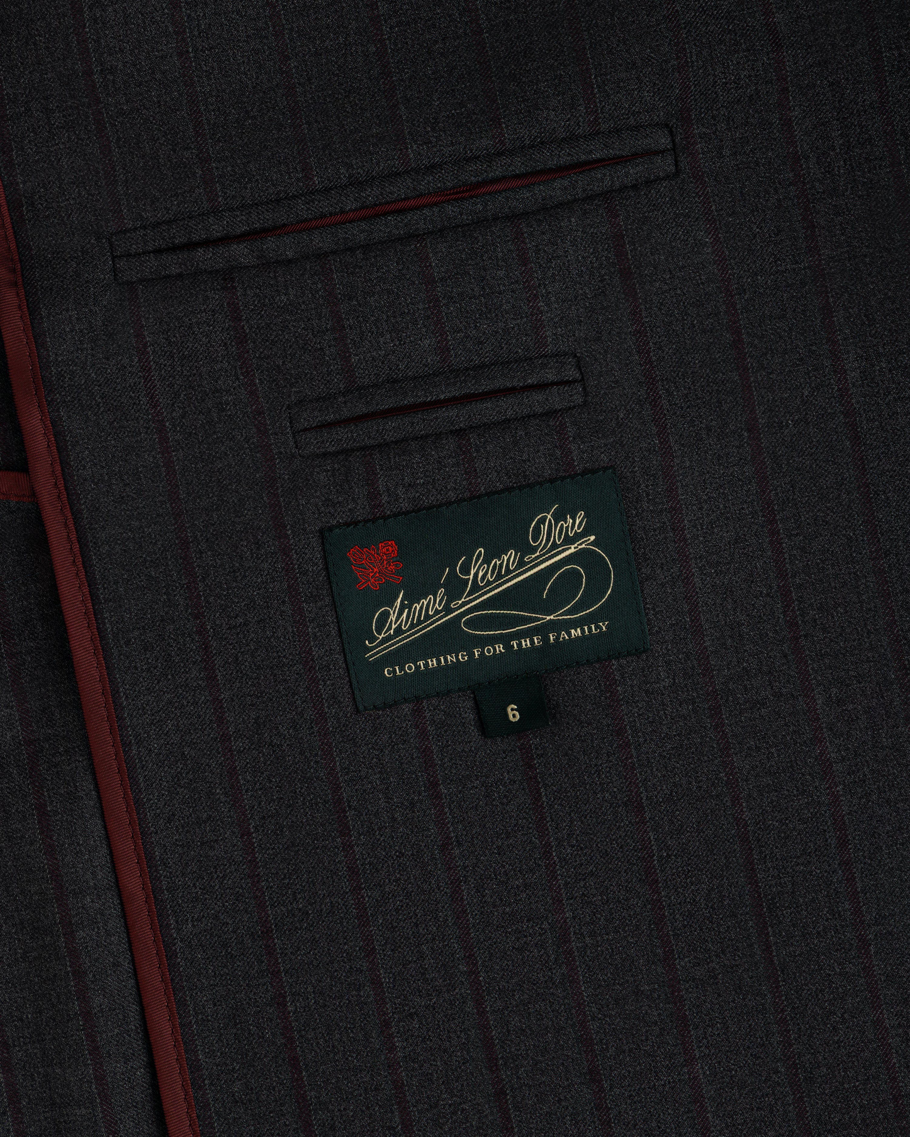 Dark gray pinstriped Collarless Striped Blazer fabric with a branded interior label and the number six on a small tab.