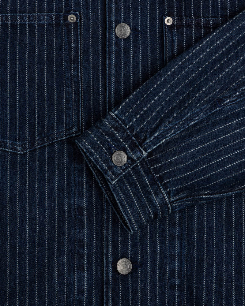 Close-up of the Chalk Stripe Denim Trucker Jacket with silver snap buttons and a folded sleeve.