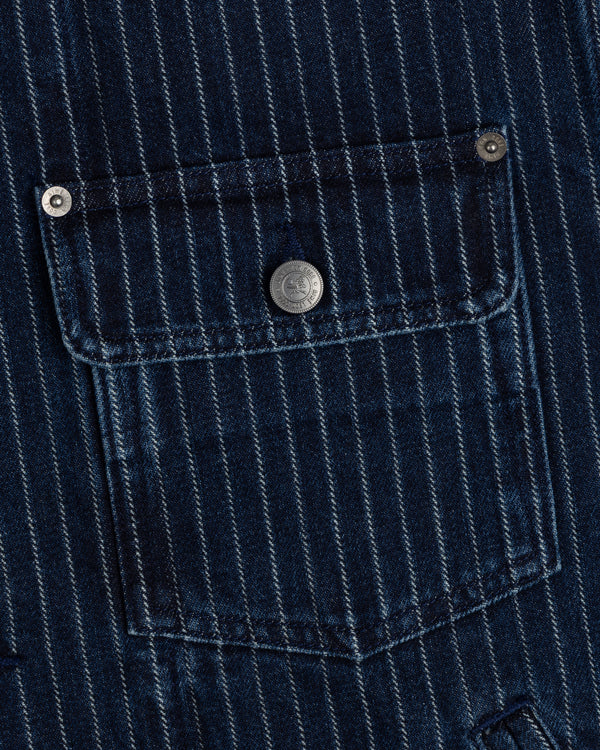 Close-up of Chalk Stripe Denim Trucker Jacket’s blue pocket with white stripes and a metal button on the flap.