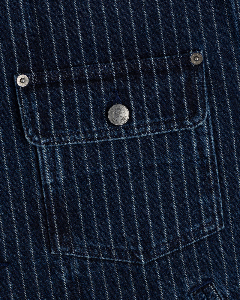 Close-up of Chalk Stripe Denim Trucker Jacket’s blue pocket with white stripes and a metal button on the flap.