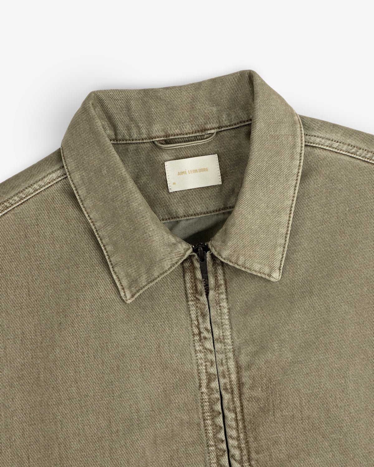 Flocked Denim Jacket in olive green, featuring a zip-up front, collared neckline, and a brand tag.