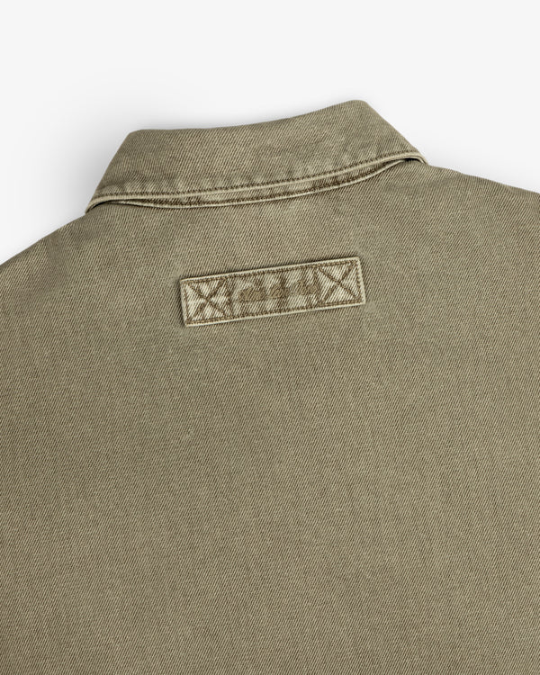 Close-up of the back collar and rectangular brand patch on a tan Flocked Denim Jacket.
