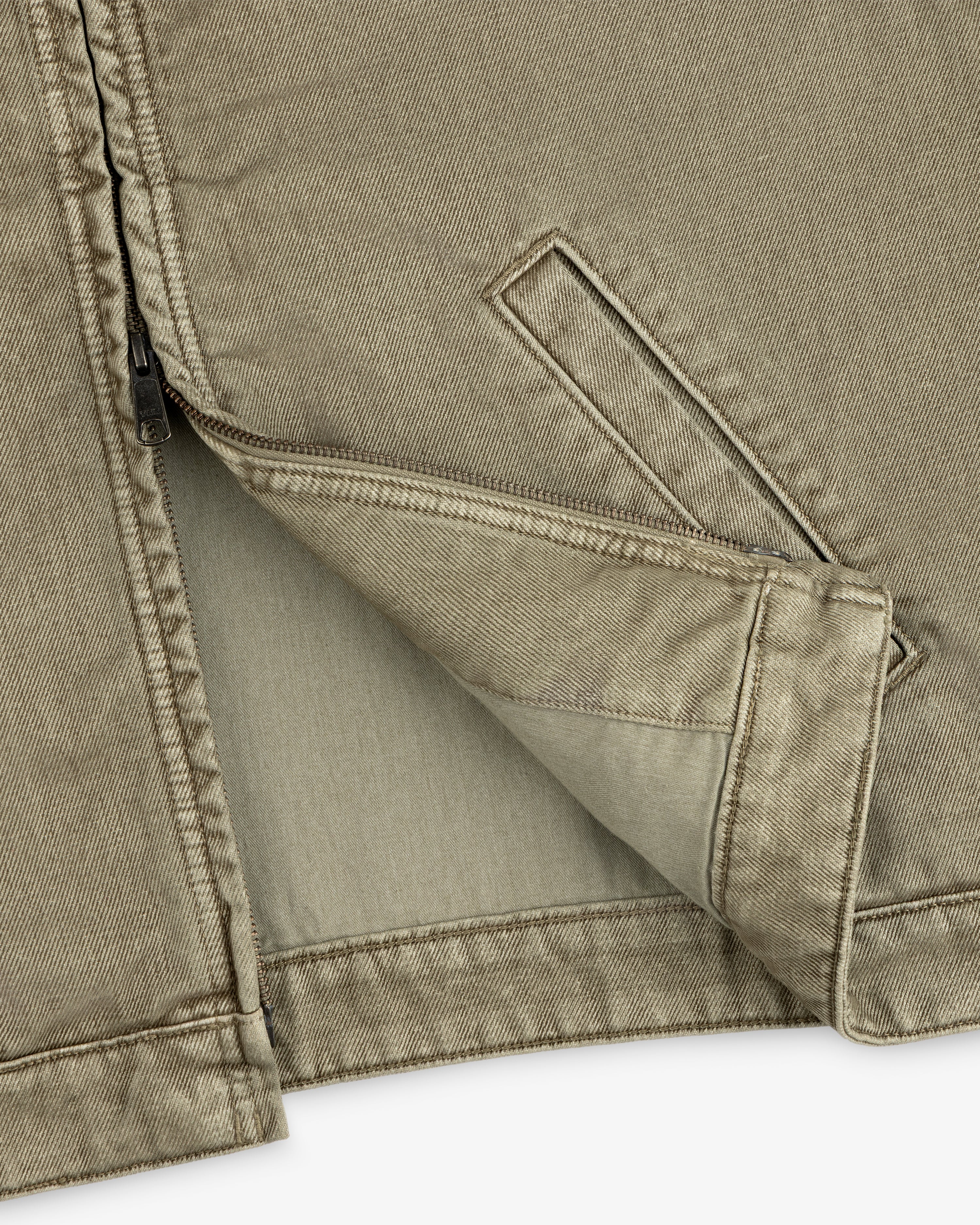 Close-up of a tan Flocked Denim Jacket featuring a zipper and a slanted welt pocket.