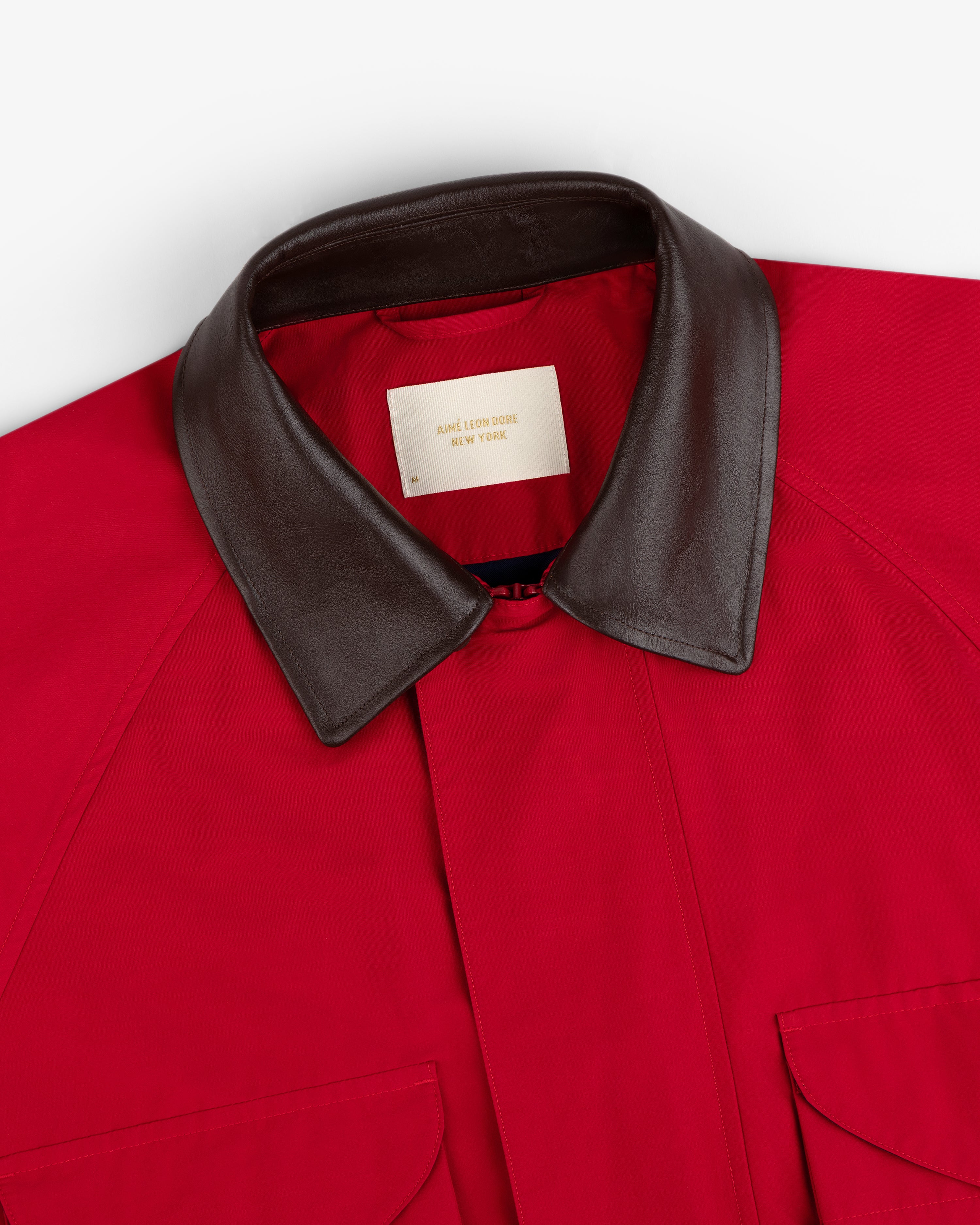 Lightweight Barn Jacket in red with a brown leather collar, two front pockets, and a visible inner label.