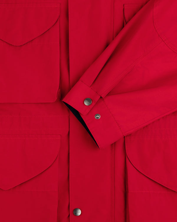 Close-up of the Lightweight Barn Jacket in red, featuring flap pockets, snap buttons, and a crossed sleeve detail.