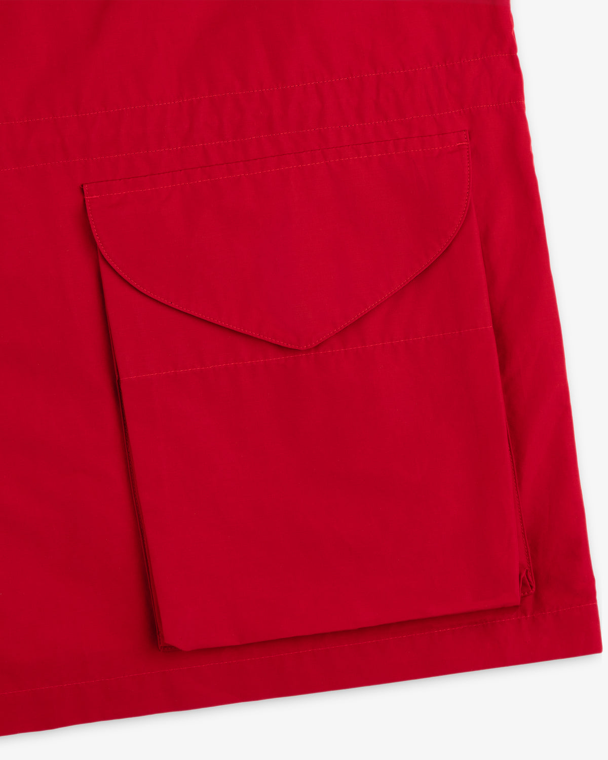 Close-up of the Lightweight Barn Jacket’s red fabric with a large rectangular flap pocket stitched on.