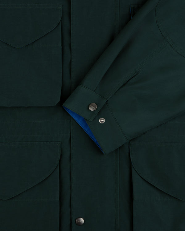 Lightweight Barn Jacket in dark green, close-up of pocket flaps, snap buttons, and overlapping sleeve.